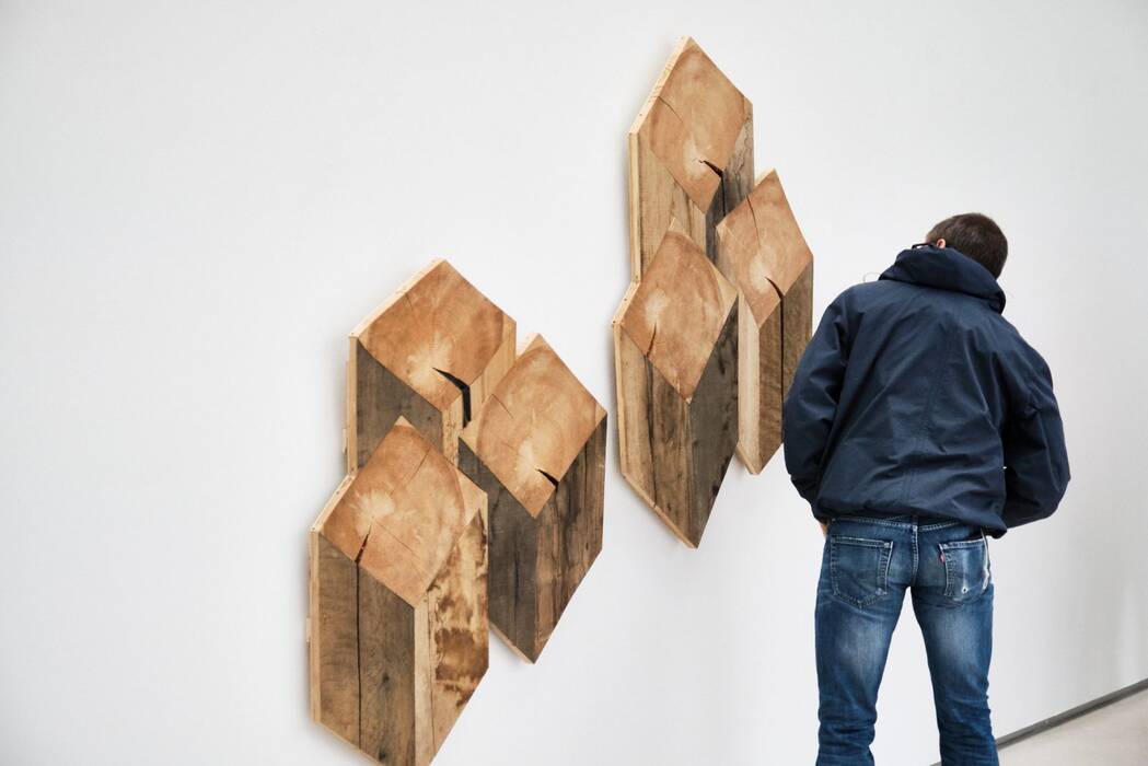 Zwei Wandskulpturen aus Holz: Jeweils drei vierkantige Hölzer bilden eine Gruppe mit Pseudo-3D-Effekt. Robert Steng, "Brettspiele", 2020.