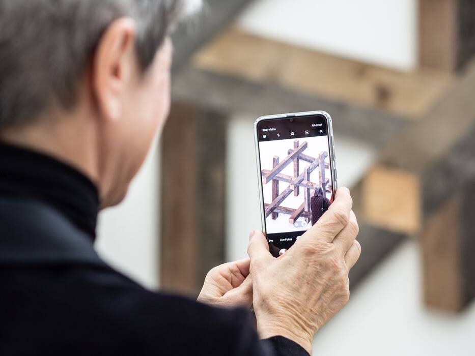 Besucher fotografiert die Wandskulptur "Big Cube" von Robert Steng.