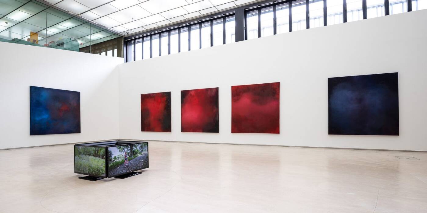 An den Wänden dominieren 5 großformatige, quadratische Malereien. Auf dem Boden steht ein Kubus aus Bildschirmen. Ausstellung "Thinking About Video Art, Kunst am Wegesrand" von Anette C. Halm