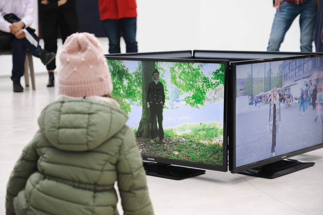 Ein Kind betrachtet die Performances auf dem Bildschirm. Ausstellung "Thinking About Video Art - Kunst am Wegesrand" von Anette C. Halm
