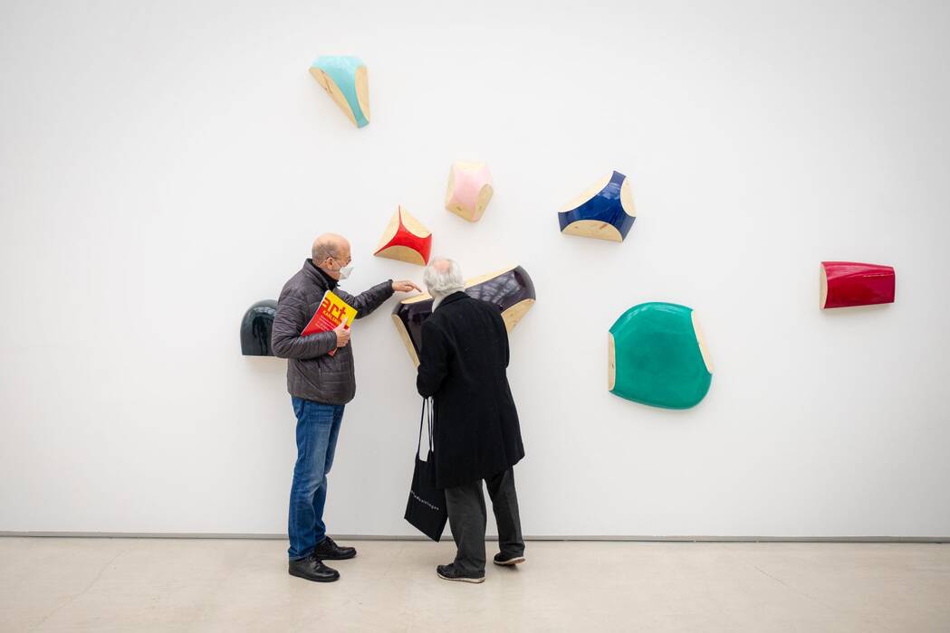 Ausstellungsbesucher vor den Wandarbeiten Günther Holders.