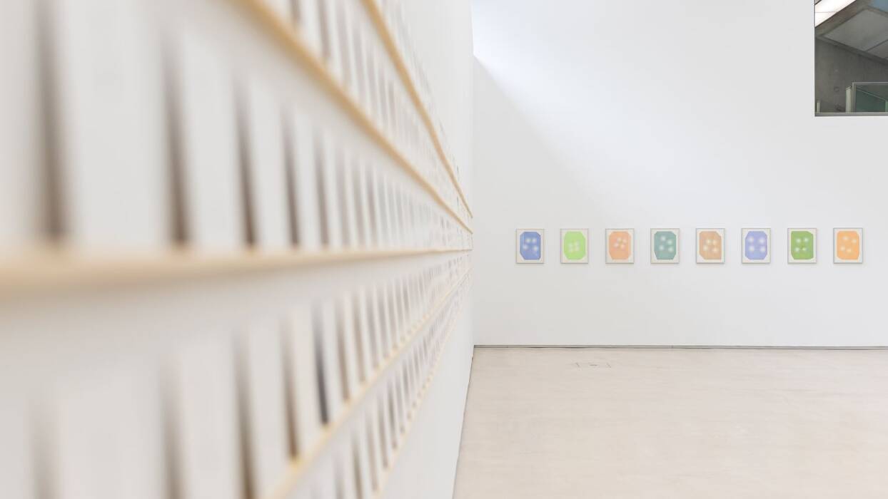 An der Wand hängt die Zeichnungsserie "four dots coloured" von Michelin Kober in Pastelltönen.