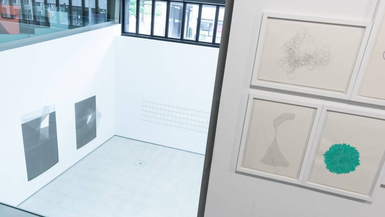 Rechts: Tuschezeichnungen "Drauf und Dran" von Michelin Kober. Blick hinunter in den Galerieraum. 