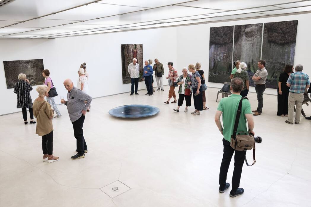 Mehrere Besuchergrüppchen vor den Fotografien der Künstlerin Isabell Munck.