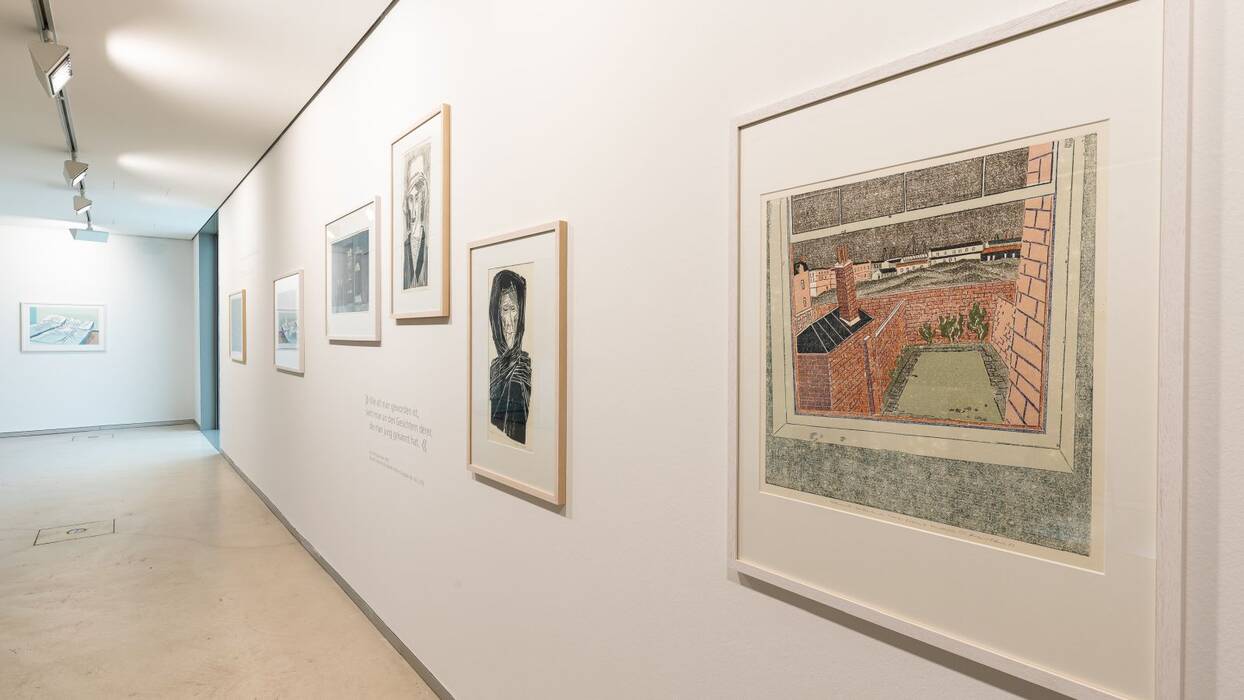 Oberer Galerieraum: Farbige Linolschnitte und Zitate. Motive: Porträts, ein Blick durchs Fenster auf einen Garten und ein Bett mit zerknitterten Laken.