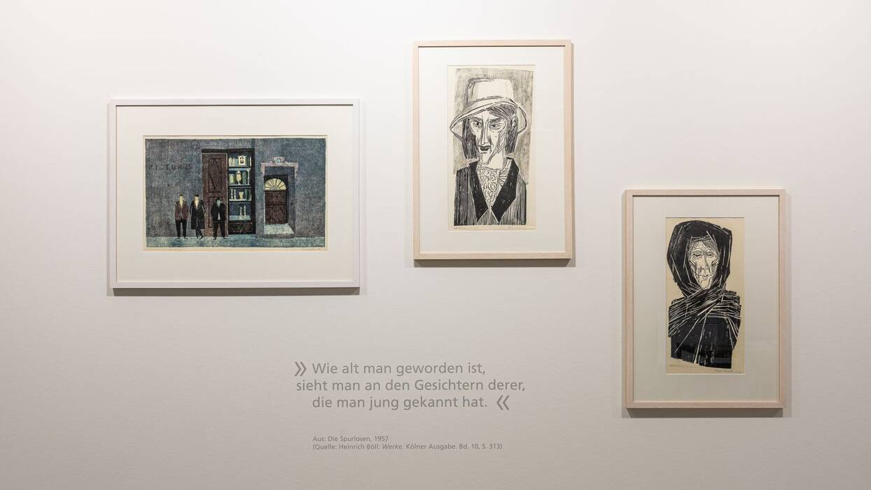 Gerahmte Linolschnitte - ein Querformat und zwei Hochformate. Zitat: "Wie alt man geworden ist, sieht man an den Gesichtern derer, die man jung gekannt hat".