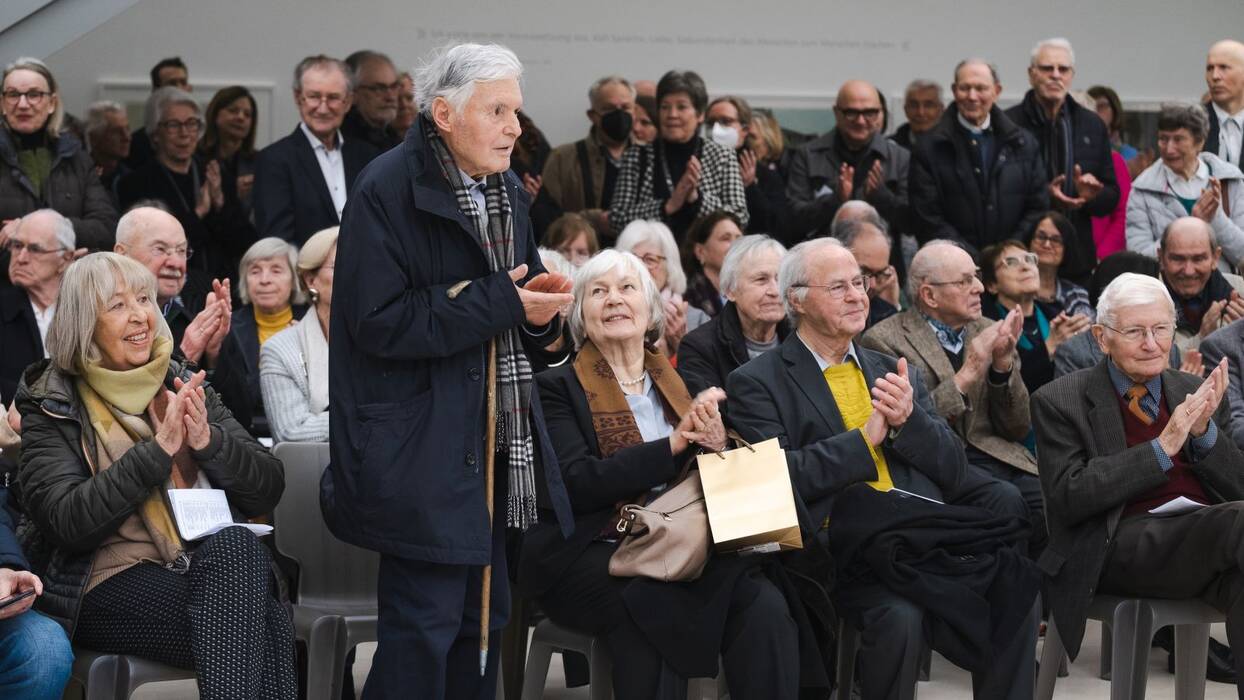 Applaudierendes Publikum. In der Mitte der Künstler Robert Förch.