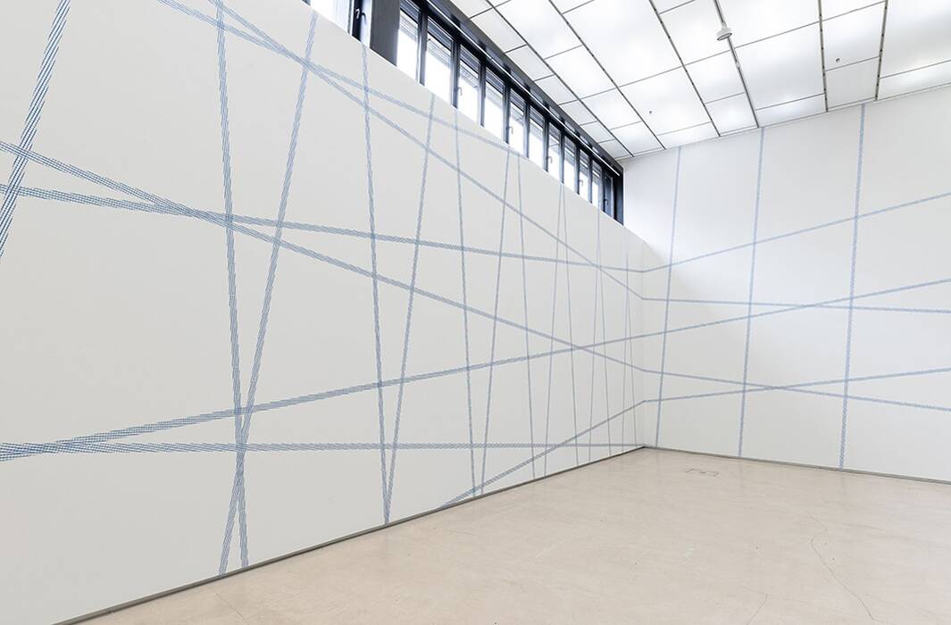 Die Galeriewände sind mit zwei versetzten Rastern aus blauem Klebeband versehen.