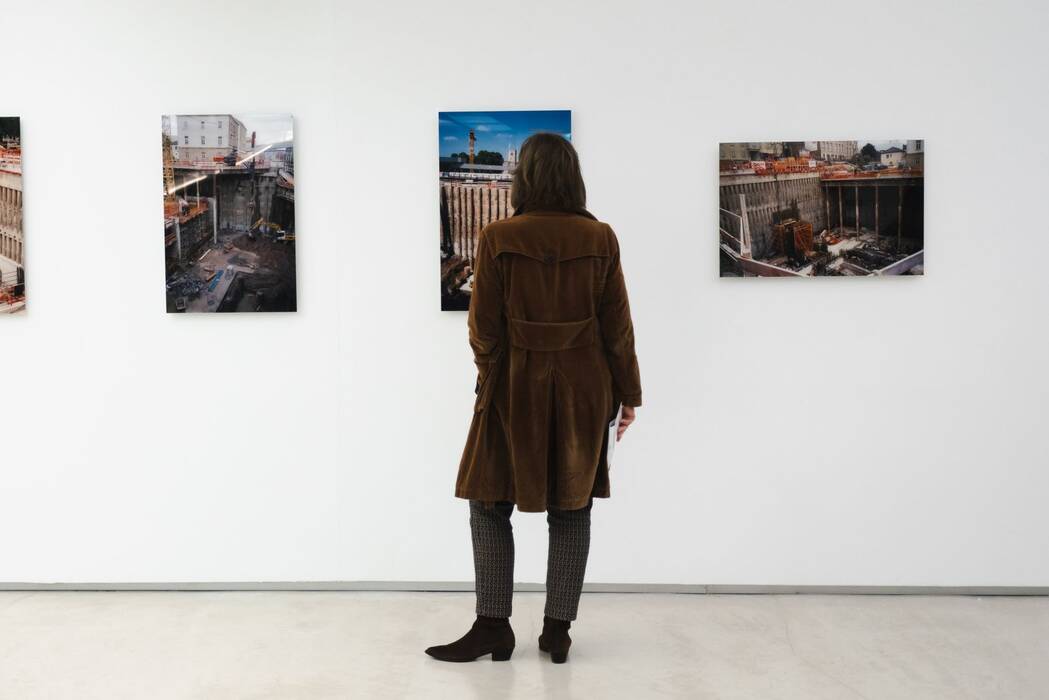 Eine Besucherin betrachtet die Farbfotografien der Baustelle "Stuttgart 21".