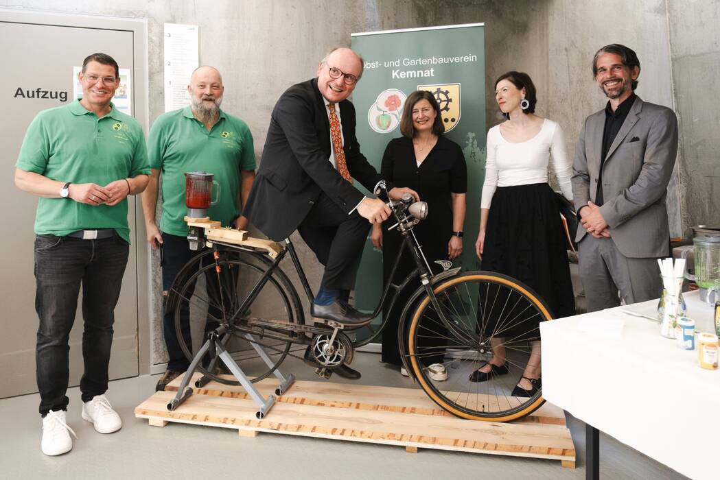 Christian Köhler, Vorstand der Kunststiftung Rainer Wild, auf dem Upcycle-Smoothie-Rad des Obst- und Gartenbauvereins Kemnat, umrundet von Frau Nann, Frau  Kouris, Herrn Blank und zwei Mitgliedern des OGV