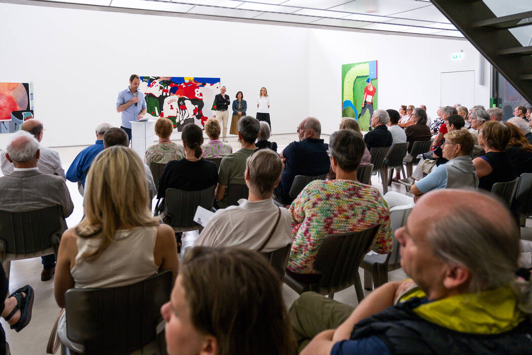 Hendrik Bündge bei seiner Eröffnungsrede - Im Hintergrund Bilder von Noemi Strittmatter, davor Galerieleiterin Holle Nann und Noemi Strittmatter