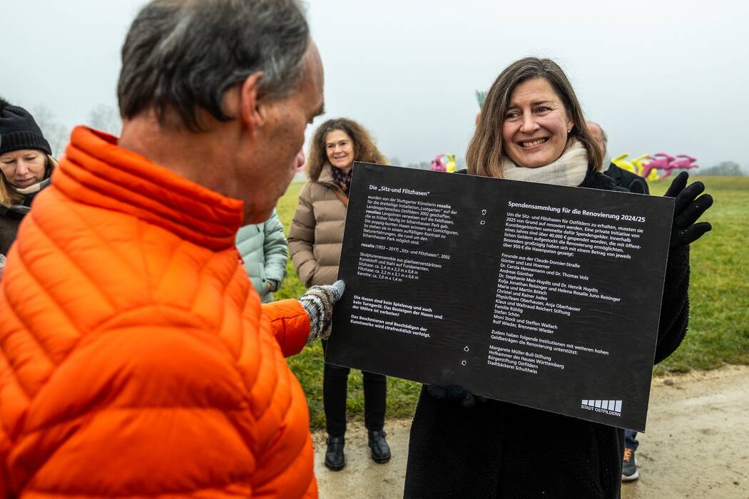 Galerieleiterin Holle Nann präsentiert das Schild mit den Spendernamen