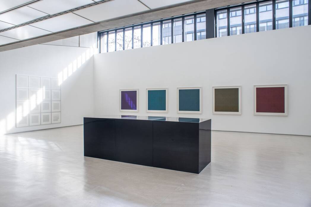 Ausstellung Sol LeWItt: Im Vordergrund das Werk Black Cubes, drei schwarze Quader (100 x 300 x 100 cm), Emaille auf Fiberglas, im Hintergrund fünf gerahmte Siebdruck-Blätter (118 x 118 cm) in rot, olive, blau, grün und aubergine aus dem Besitz der Stadt Ostfildern. An der linken Wand 16 schwarz-weiße Lithografien (Lines Of One Inch In Four Directions Ánd All Combinations) von Sol LeWitt in hellen, quadratischen Rahmen