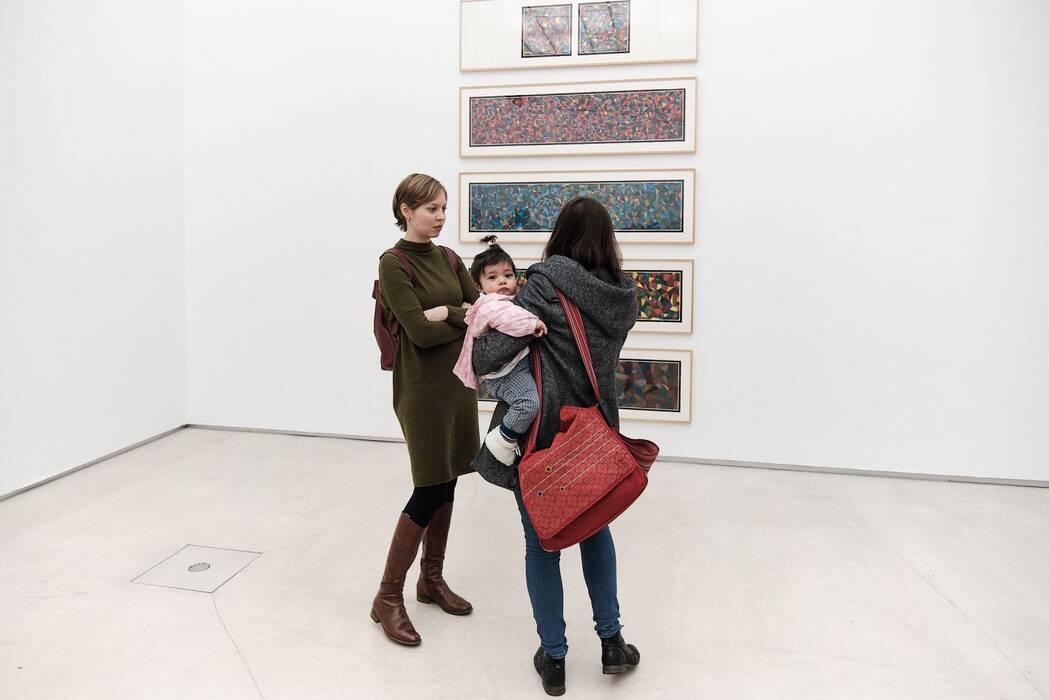 Zwei Ausstellungsbesucherinnen betrachten den fünfteiligen, farbigen Siebdruck "Complex Forms (je 150 x 43 cm Blattmaß) von Sol LeWitt aus dem Jahr 1990 